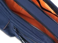 Detalje af mørkeblå taske fra Mads Nørgaard med lynlåse og orange foer